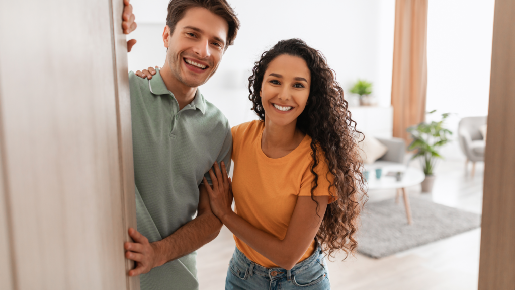 A homeowner providing on-site assistance to a photographer setting up equipment in the living room, pointing out key areas of the house to the photoshoot crew. 